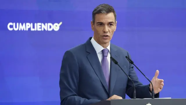 Spain's Pedro Sanchez speaks during a press conference wearing a suit.