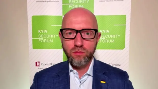 Ukraine's former prime minister wears a suit and glasses.
