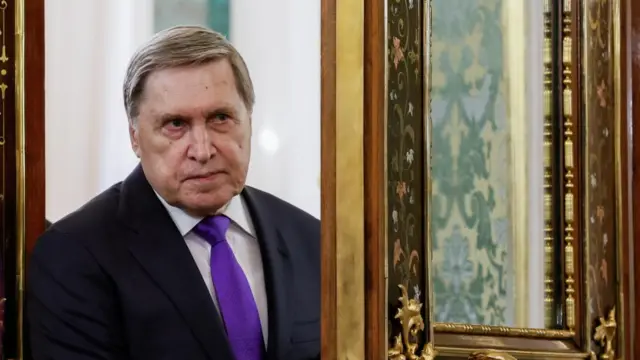 Kremlin aide Yuri Ushakov wears a suit and looks ahead.