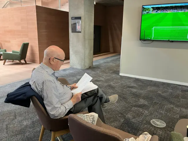 ... while Archie MacPherson checks his pre-match notes!