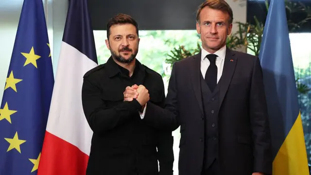 France's President Emmanuel Macron (L) shakes hands with Ukraine's President Volodymyr Zelensky