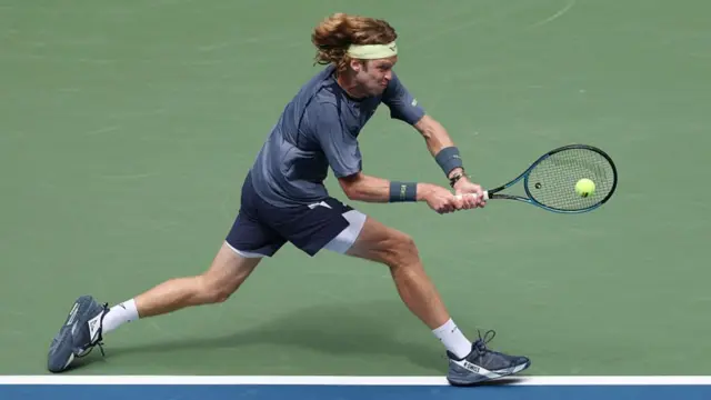 Andrey Rublev returns with a backhand vs Felix Auger-Aliassime