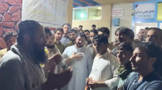 A group of people gather at a hospital to donate blood