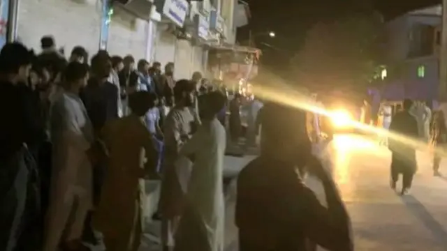 A crowd of Afghan men gathered on a street in Asadabad, Afghanistan.