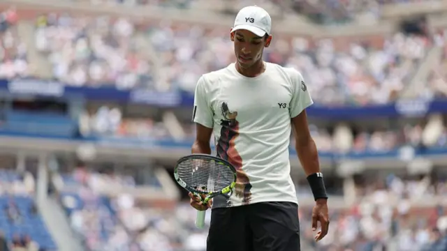 Felix Auger-Aliassime looks at his racquet