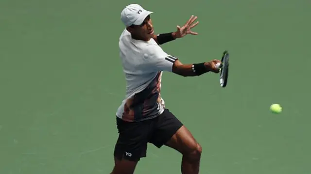 Felix Auger-Aliassime returns with a forehand