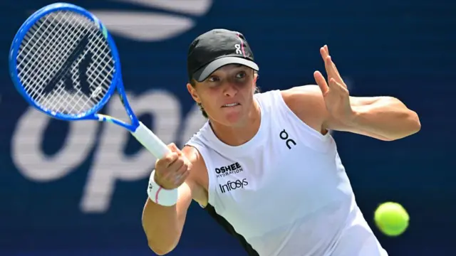 Iga Swiatek returns with a forehand