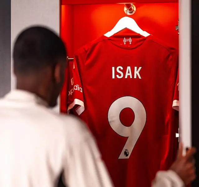 Isak looks at his new number Liverpool shirt after signing