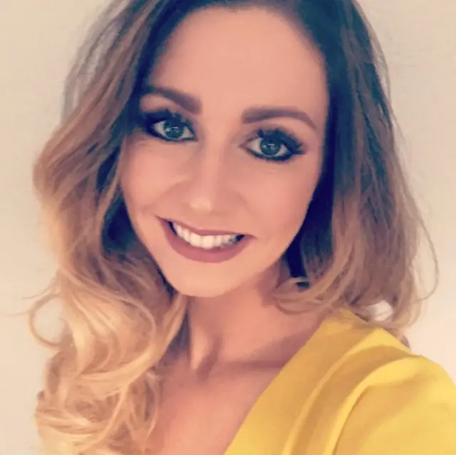 Heidi Liddle, who has wavy blonde hair, smiles at the camera as she takes a selfie