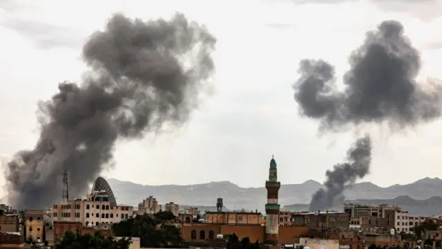 A view of the skiline of Sana'a, over which two plumes of smoke rise into the sky