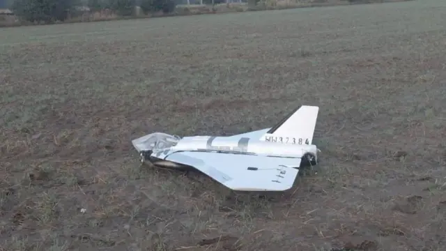 A large white drone lying in a field