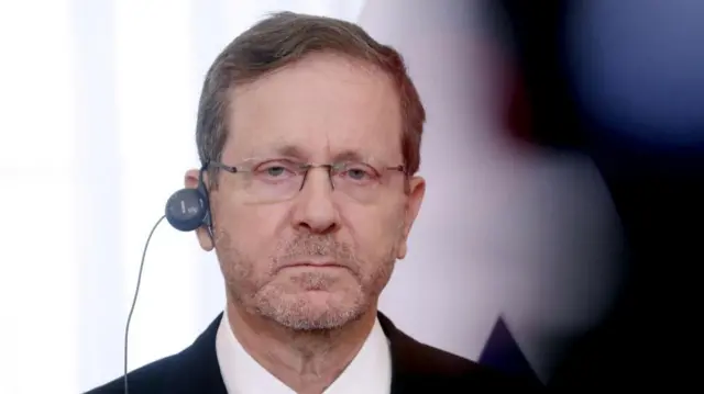 Herzog with an ear piece in and glasses