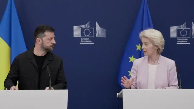 Zelensky and von der Leyen speaking at podiums, facing eachother