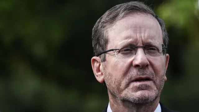 Israeli President Isaac Herzog looks ahead, wearing glasses.