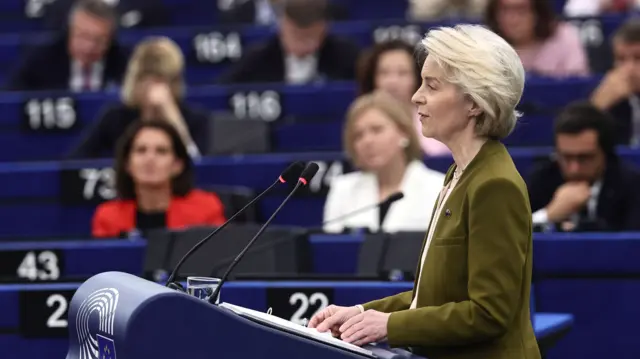 Ursula von der Leyen stands at a blue profile addressing the crowd