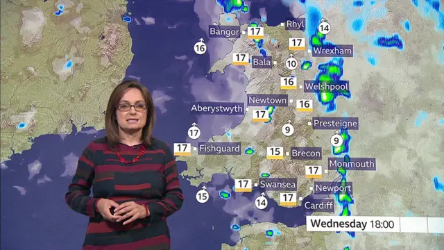 Sue Charles stands in front of a weather map of Wales