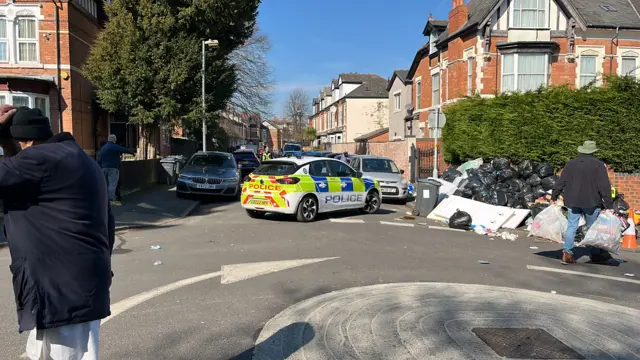 A police car next to a mountain of big bags