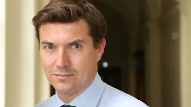 James Roscoe wears a blue shirt and looks into the camera