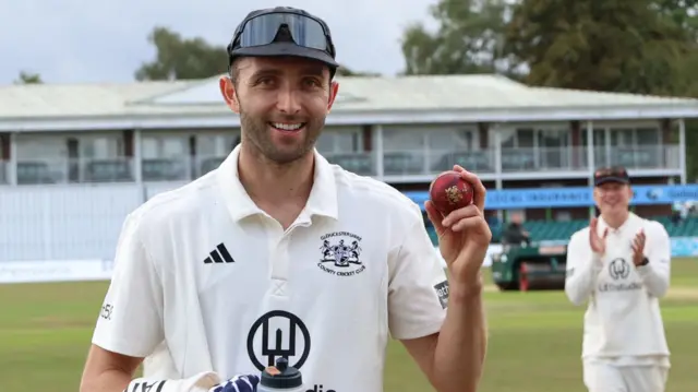 Matt Taylor holding the ball after taking 5-70 against Leicestershire