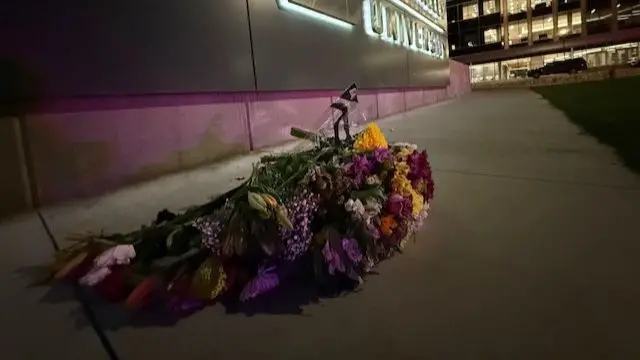 bouquets of flowers have been left on a footpath at the university