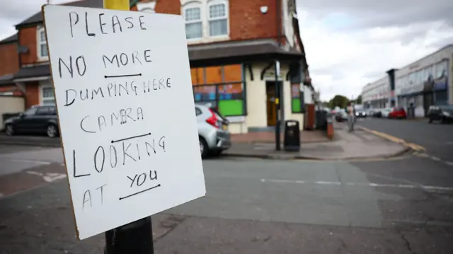 Sign reading please no more dumping here, camera looking at you