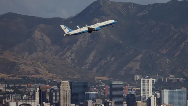 Air Force Two departs from Salt Lake City airport. City buildings are seen in the background.