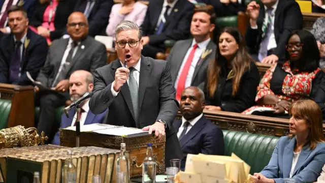 Keir Starmer, wearing a suit and tie, passionately addresses the Commons whilst MPs sit on benches behind him
