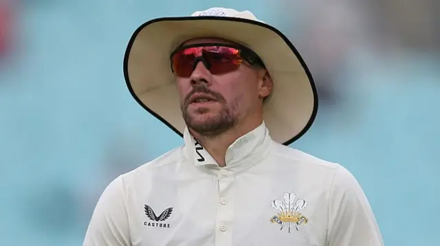 Rory Burns in the field in a sun hat