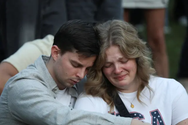 People react during a vigil at Orem City Center Park, after U.S. right-wing activist and commentator