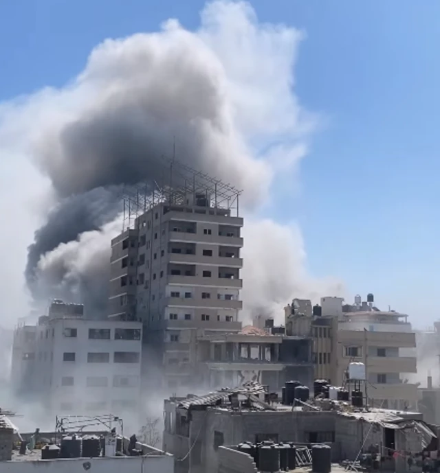 A large building with a plume of smoke behind it