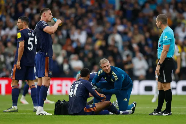 Jacob Ramsey getting treatment for an ankle injury against Leeds