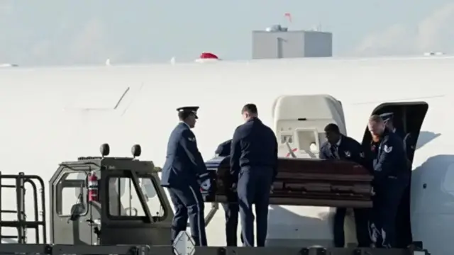 Kirk casket being carried out of plane by several men
