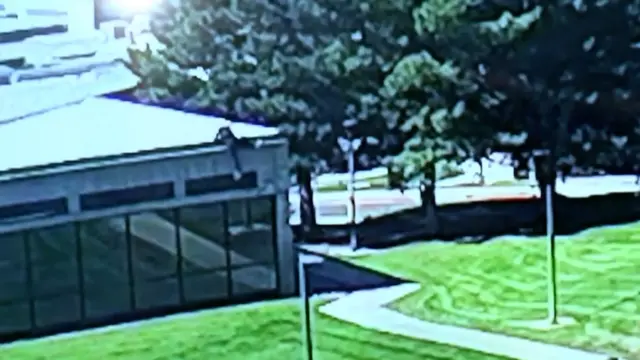 CCTV footage shows a man, wearing black clothes, climbing down the side of the building.