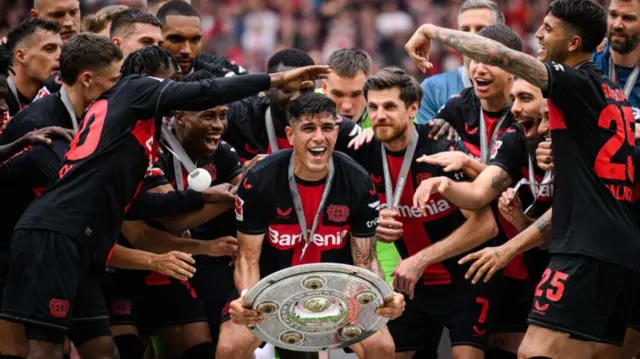 Piero Hincapie lifts the Bundesliga trophy