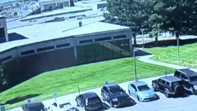 CCTV footage shows a man, wearing black clothes, running across the roof of a building.