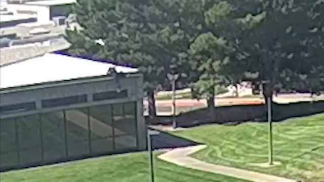 CCTV footage shows a man, wearing black clothes, climbing down the side of the building.