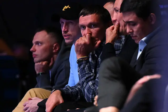 Boxer Oleksandr Usyk watches the World Boxing Championship. His hand covers his mouth.