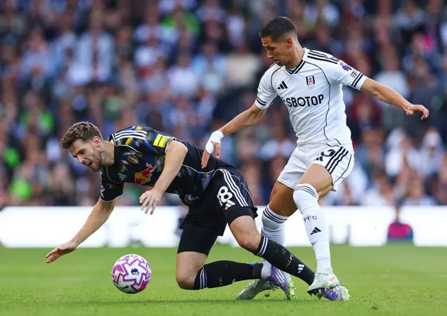 Arthur Vermeeren of RB Leipzig is challenged by Sasa Lukic of Fulham during the Premier League match between Fulham and Leeds United at Craven Cottage on September 13, 2025 in London, England.