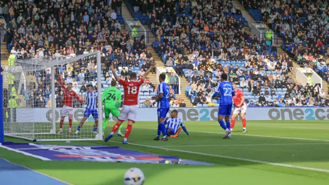 Bristol City players throw their hands in the air as the ball crosses the line