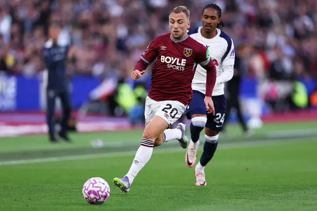 Jarrod Bowen of West Ham United battles for possession with Djed Spence of Tottenham Hotspur during the Premier League match between West Ham United and Tottenham Hotspur at London Stadium on September 13, 2025 in London, England.