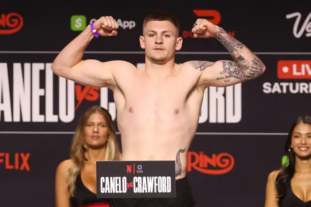 Callum Smith flexing his biceps on the scales
