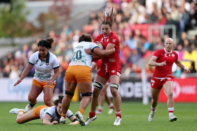 : Caroline Crossley of Canada is tackled by Ashley Marsters