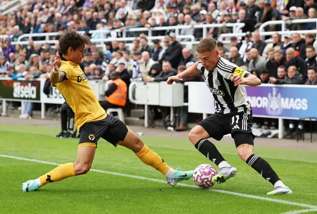 Harvey Barnes of Newcastle United and Hugo Bueno of Wolverhampton Wanderers during the Premier League match between Newcastle United and Wolverhampton Wanderers at St James' Park