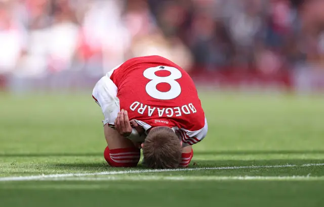 Martin Odegaard of Arsenal holds his shoulder after a challenge during the Premier League match between Arsenal and Nottingham Forest at Emirates Stadium on September 13, 2025 in London, England.
