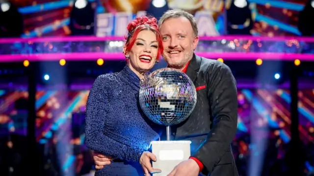Dianne Buswell and Chris McCausland holding the glitter ball trophy