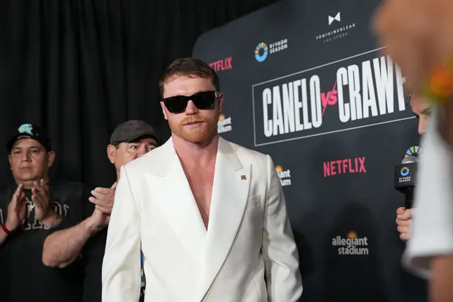Saul 'Canelo' Alvarez in a white suit and sunglasses
