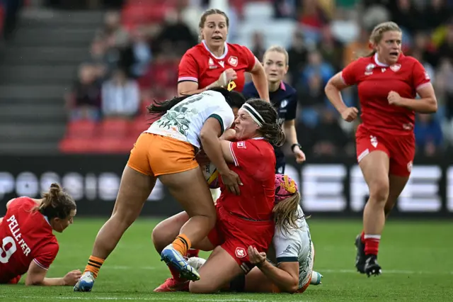 Canada's prop DaLeaka Menin (C) is tackled