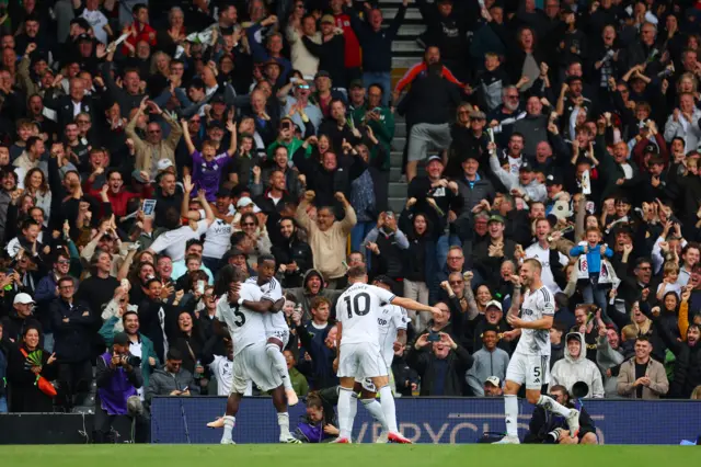 Fulham players celebrate their first goal, an own goal scored by Leeds United's Gabriel Gudmundsson