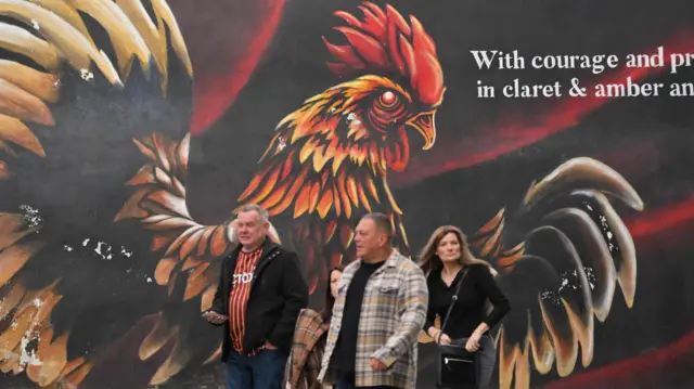 Bradford fans walking in front of a Bantams mural
