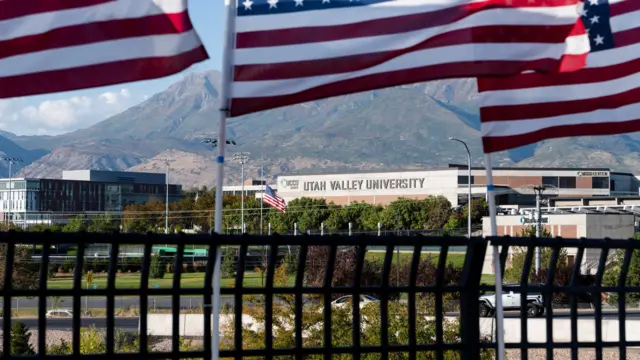 Wide shot of exterior of Utah Valley University with two US flags flying in the foreground